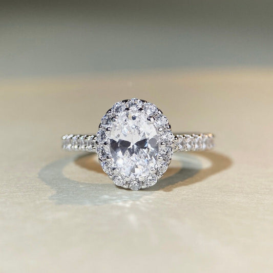 Diamond ring with a halo on a beige surface